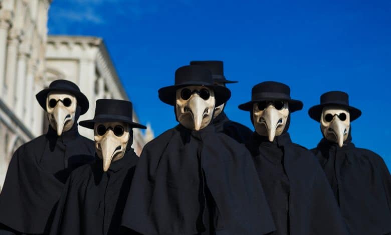 الأوبئة - صورة مجموعة من الناس ترتدي أقنعة الطاعون الأسود وأردية سوداء
