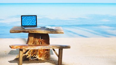 مكان العمل - حاسوب محمول على طاولة على الشاطئ